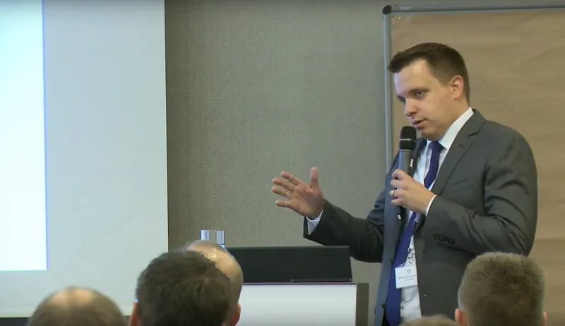 Benjamin Aunkofer spricht mit Mikrofon vor Publikum